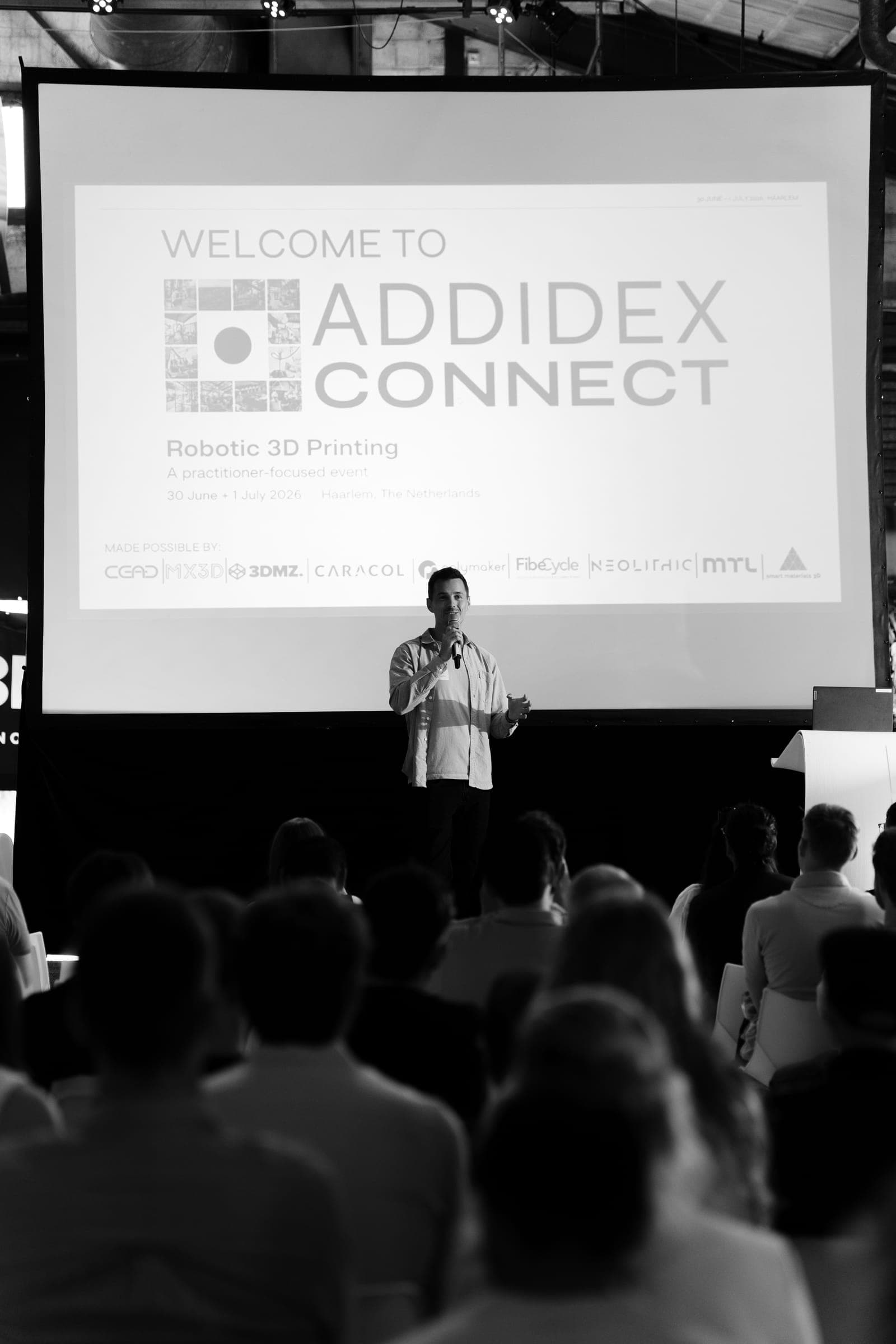 Presenter welcoming attendees on stage